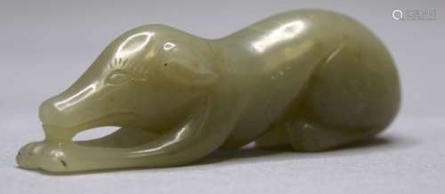 A CELADON JADE CARVING OF A CROUCHING DOG