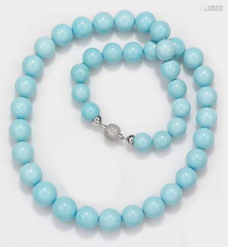 A turquoise necklace with a gold diamond clasp