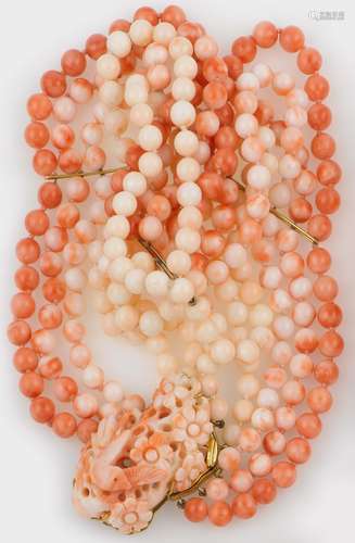 A coral necklace with a carved coral clasp