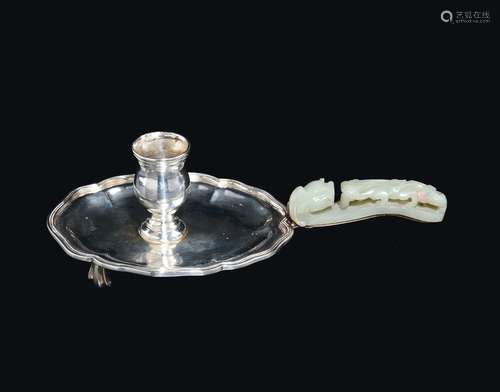 A silver candlestick with white jade 