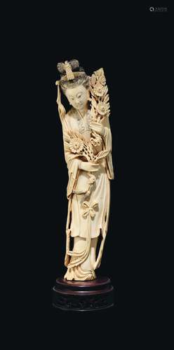 A carved ivory figure of Guanyin with flowers, China, early 20th century