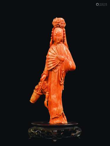 A carved coral figure of Guanyin with fan and basket of flowers, China, early 20th century