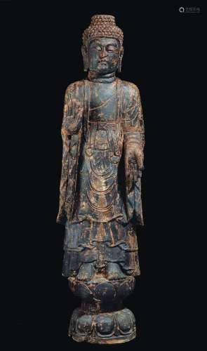 A large carved polychrome wood figure of standing Buddha on a lotus flower, China, Ming Dynasty, 17th century