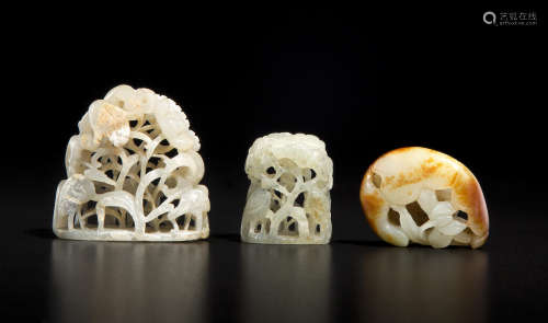a group of three small reticulated jade carvings