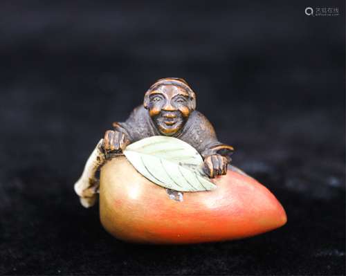 A POLYCHROME WOOD NETSUKE OF BOY AND PEACH