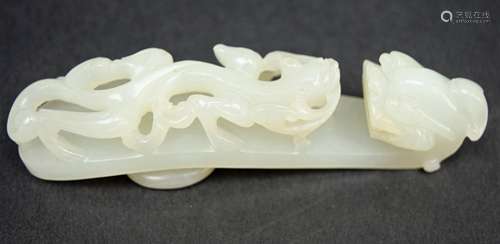 Jade garment hook. 19th century. China. Litchee white stone carved with a chih lung and dragons head finial. 4-1/2