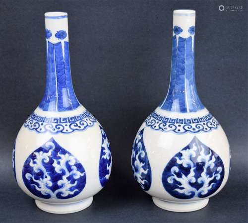 Pair of porcelain vases. China. 19th century. Bottle form. Decoration of banana leaves at the neck. Ju-I border and jewel shape floral medallions. 9-1/2