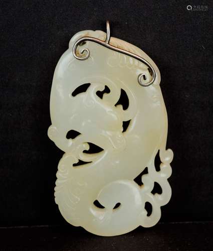 Jade pendant. China. 18th century. White stone with areas of yellow. Carving of a swirling dragon. Silver mount. 2-1/2