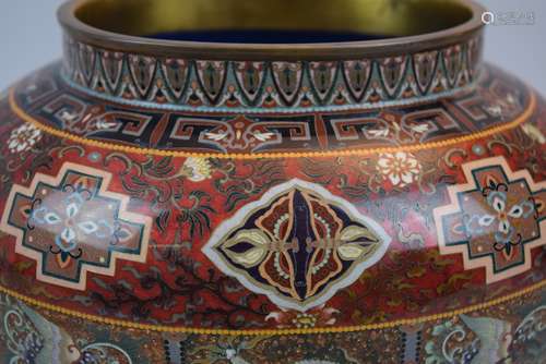 Large Cloisonné covered jar. Japan. Meiji period (1868-1912). Oval form. Silver wire work. Top decorated with shishi and stylized peony scrolls on a goldstone ground. Jar decoration with various brocade patterns and reserves of dragons and phoenixes on a lighter goldstone ground with a base of mustard yellow. Possibly Ando Jubei. 9