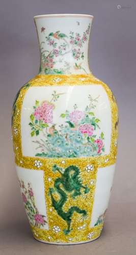 Porcelain vase. China. Late 19th century. Famille Rose decoration of reserves of flowers and birds on dragon and flower strewn yellow ground. K'ang H si mark on the base. 16-1/2