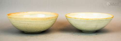 Two Ying Ching bowls. China. 13th century. One with carved floral scrolling, the other with molded decoration. Each about 6-1/4