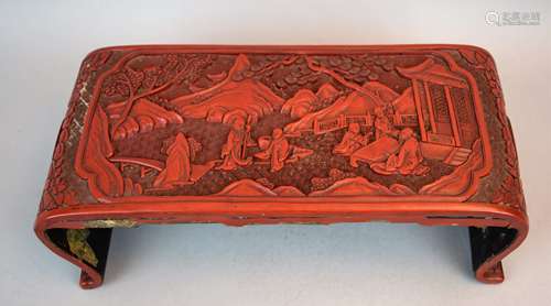 Arm rest. China. Carved cinnabar lacquer. Surface decorated with figures in a landscape and floral scrolling. 12