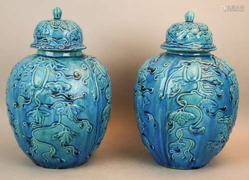 Pair of porcelain covered jars. China. Early 20th century. Molded decoration of gourd plants and flowers beneath a deep turquoise glaze. 12