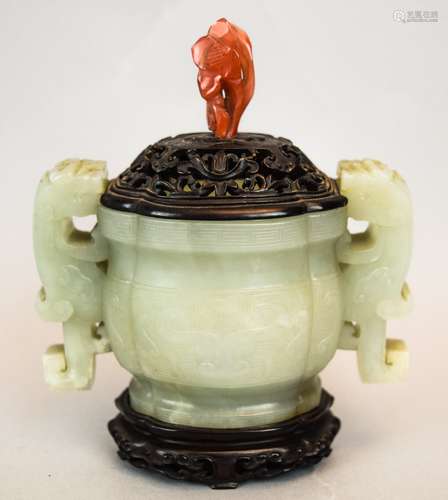 Jade censer. China. Ch'ien Lung period. (1735-1796). Archaic style ritual Kuei shape. Stone of a highly translucent celadon colour. Dragon handles. Surface carved with Tao Tie masks. Fitted hardwood stand and cover with a carnelian finial. 4