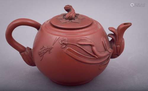 Terracotta teapot. China. 20th century. Yi Hsing ware. Carved decoration of flowers and insects. Foo Dog finial. Signed on the base and on the interior of the lid. 7-1/4 l.   4