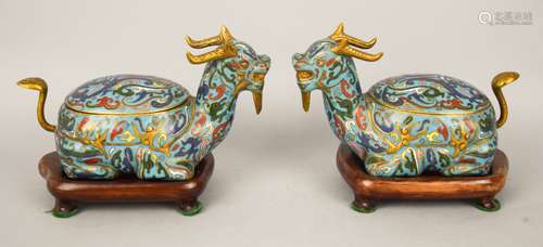 Pair of Cloisonné boxes. China. Circa 1950. Shaped as horned mythical animals. Dark turquoise ground with Tao Tieh masks and swirling phoenixes. Fitted wooden stands. 7-1/2