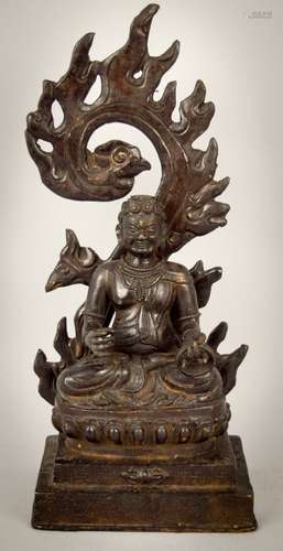 Bronze Buddhist image. China. 20th century. Tibetan style figure of a seated Tantric Divinity with a flame halo at the back. 10-3/4