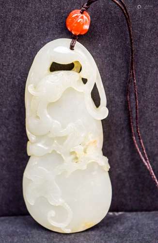 Jade pendant. China. 19th century. Double gourd form with a Chih Lund. Grey green stone with brown markings. 3-1/2