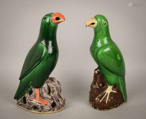 Two porcelain parrots. China. 18th/19th century. Figures standing on a rocky out crop. Deep forest green glaze with aubergine coloured ricks. One with coral coloured beak and feet. Each about 8-1/4