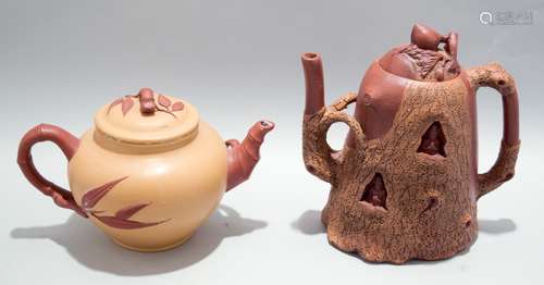 Two stoneware teapots. South China. 20th century. Yi Hsing ware. One carved as a root section with hollowed out Buddha's, the other tan and red carved with elements of bamboo.  6-1/2