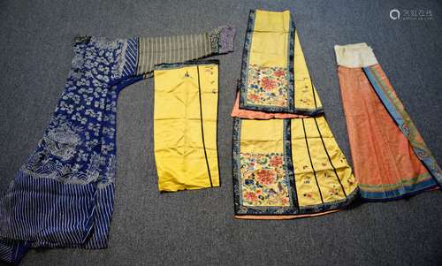 Lot of three textiles. China. Late 19th century- early 20th century to include a gauze weave dragon robe and two skirts, one with drain stitch embroidery. Condition: One skirt cut in two parts, others with toning, staining and pulled threads.