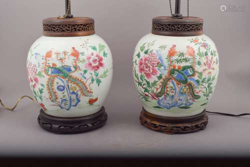 Pair of porcelain jars. China. 19th century. Ovoid shape. Famille Rose decoration of phoenixes and flowers. Wooden covers and stands. Drilled and mounted as lamps. 8