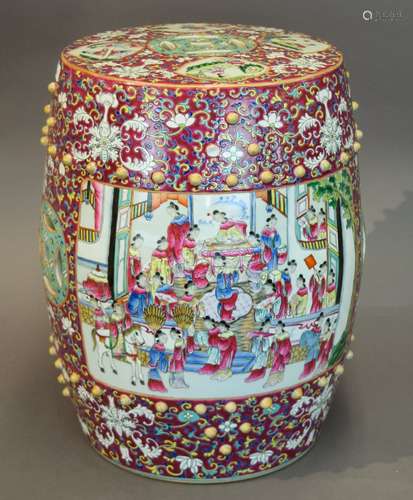 Porcelain garden. China. 20th century. Barrel drum form with cash coin piercings. Famillie Rose reserves of men and women in palace scenes. Magenta ground with stylized lotus scrolls. 18-1/2