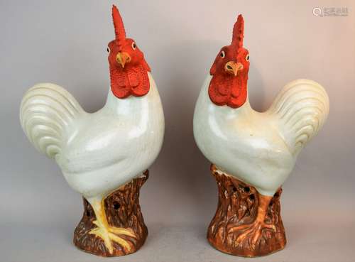 Pair of porcelain roosters. China. 19th century. Celadon ground with the bodies carved with feathers. Coral coloured heads. Bases of rocky outcrops with a brown glaze. 15-1/2