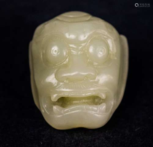 Jade pendant. China. 18th century. Pale celadon coloured stone. Carved in the form of a demons head. 1-1/4