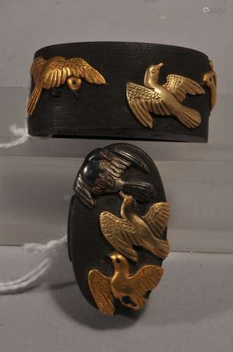 Set Fuchi-Kashira, Japan. 18th/19th century. Signed. Copper with mixed metal inlay of gold, shakudo and silver. Decoration of doves on a nanako ground. Signed and with a kakihan.