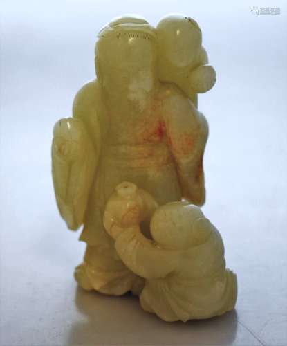 Jade carving. China. 18th century. Ice green stone with russet markings. Shao Lao with two children holding pomegranates and peaches. 4-1/2