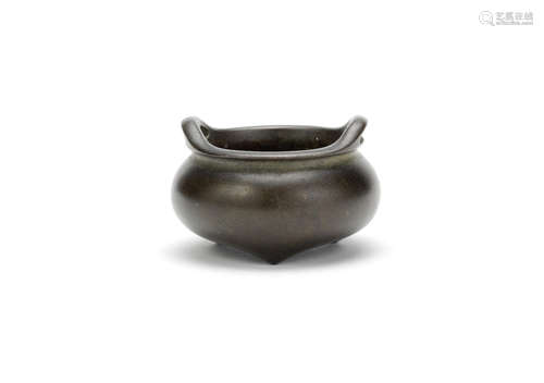 A miniature bronze tripod incense burner