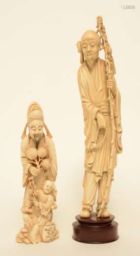 A Chinese ivory figure of a monk, on a wooden base, late Qing period, H 36 cm (whithout base); added a Chinese ivory figure of a Mandarin with a child, on a wooden base, scrimshaw decorated, early 20thC, H 25,5 cm