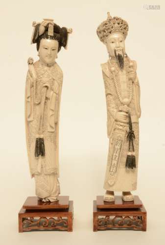 A pair of Chinese ivory figures of the imperial couple, on a fixed wooden base, scrimshaw decorated, first half of 20thC, H 43 cm (man) - Weight 1.529 g / H 40,5 cm (woman) - Weight 1.358 g