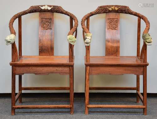 A pair of Chinese armchairs in exotic wood, the horseshoe-shaped back richly carved and crowned with jade, H 106,5 - W 66 cm