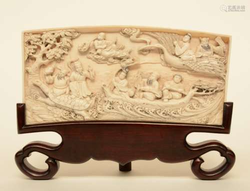 A Chinese ivory plaque on a wooden base depicting the Eight Immortals crossing the sea, Republic period, H 12,8 - W 25,5 cm, Weight: ca. 396 g