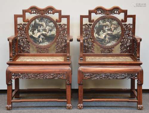 An exceptional pair of Chinese hardwood armchairs with relief decorations of dragons and marble seat, the back polychrome decorated in ivory and lacquer, ca. 1900, H 106,5 - W 69 cm (damage to the carving on one arm)