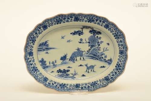 A Chinese oval dish with profiled rim, blue and white decorated with a landscape and floral motifs, 18thC, W 34 - D 26,5 cm