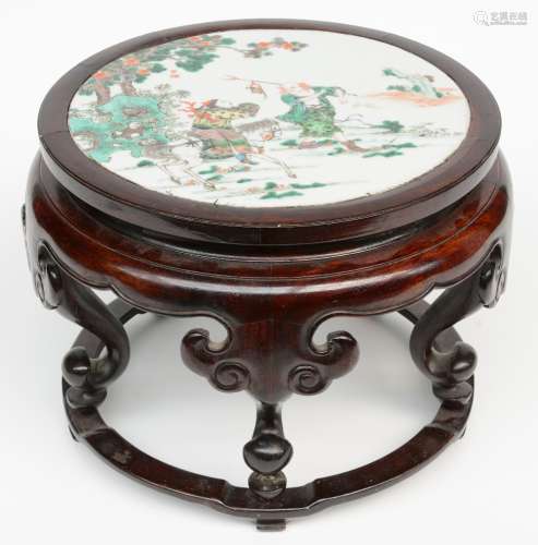A Chinese wooden stool with a famille verte plaque decorated with a genre scene, Kangxi, H 24,5 - Diameter 32 cm (one leg with restoration)