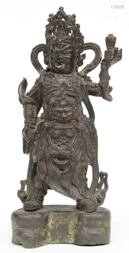 A Chinese bronze temple guard on matching base, H 33 cm (left arm restored, a part of the ribbon missing)