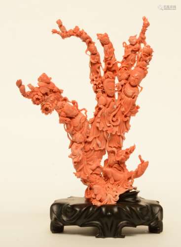 A Chinese red coral sculpture carved with figures, children, flowers and fish, on a wooden base, H 39,5 cm - Weight 2.190 g