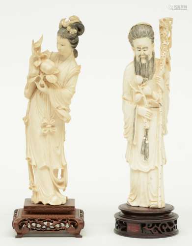 Two Chinese Canton-ivory early Republic sculptures, one depicting a beauty bearing a twig with persimmon fruits; one depicting an Immortal, both sculptures scrimshaw decorated, on a hardwood base, H 29 cm (with base) / 25,3 - 25,8 cm (without base), Weight: ca. 390 g (Immortal) - 465 g (beauty)