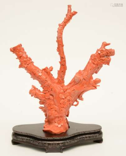 A Chinese red coral sculpture depicting a Guanyin in a garden, late Qing dynasty, with a matching base, H 37,4 cm (with base) / H 33,5 cm (without base) - W 26,9 cm, Weight: ca. 1,33 kg (minor damage)
