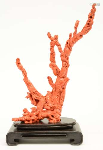 A Chinese red coral sculpture depicting a Guanyin sitting on a red dragon and accompanied by a phoenix and Ho-Ho-twin boys, with a matching base, H 44,9 cm (with base) / H 38,8 cm (without base) - W 18,9 cm, Weight: ca. 1,15 kg