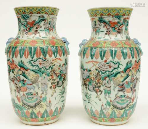 A pair of Chinese famille verte vases, overall decorated with warriors, 19thC, H 35 cm (flaking of the glaze on the relief decor, one vase with minor chips on the rim)