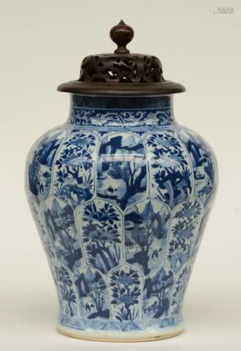 A Chinese blue and white baluster-form vase with moulded lotus petal decoration, painted with landscapes and flower branches, with later wooden cover, 19thC, H 41 cm (a hairline and firing fault on the neck, chips on the rim)
