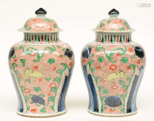 A pair of Chinese wucai vases and covers, decorated with horses, blue rocks and green leaves, Transitional period, late Ming dynasty, 17thC, H 38 cm (both vases and one cover with chips on the rim)