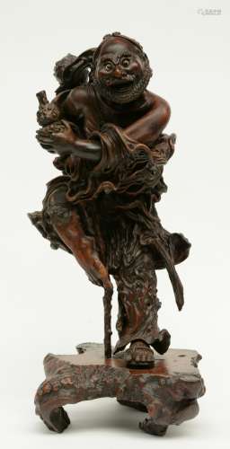 A Chinese walnut carved sculpture depicting a mythical figure, 19thC, H 64 cm (left indexfinger missing)