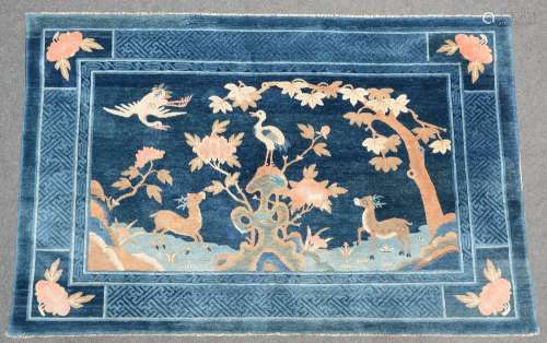 A Chinese wool rug decorated with deers, birds and flower branches, 134 x 208 cm