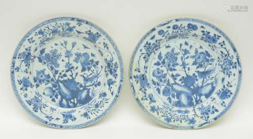 Two Chinese blue and white plates decorated with a bird and flower branches, 18thC, Diameter 39,5 cm (minor firing faults and chips to the rim, one with restoration)